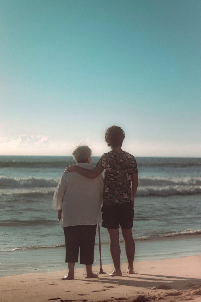 our-experience A touching moment as a grandmother and child embrace while looking at the ocean on a sunny day in Mazatlán, México.