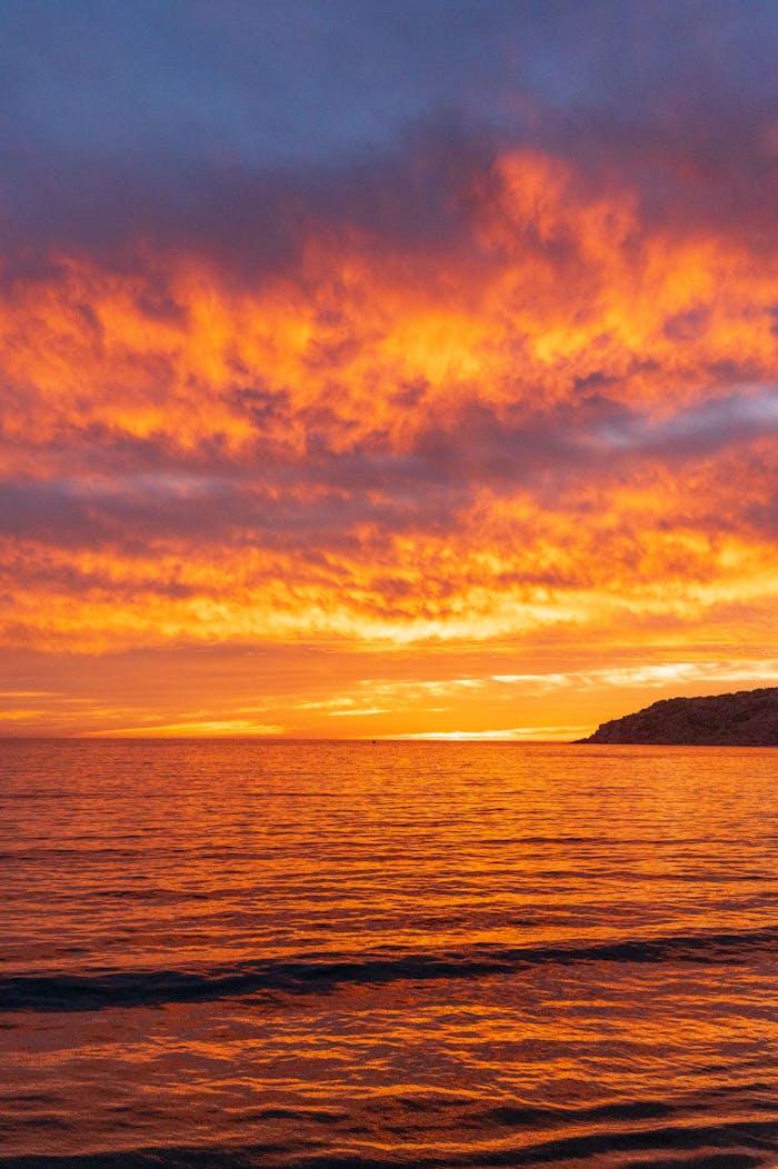 services-img Stunning sunset over Mazatlán beach with vivid orange and blue skies reflecting on the ocean.